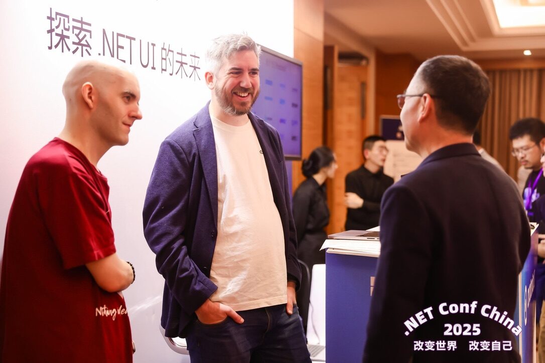 Avalonia team members in conversation with an attendee at the .NET Conf China 2025 booth